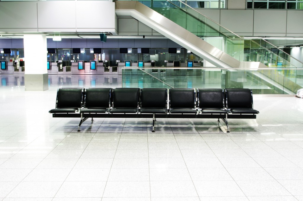 Im Wartebereich des Düsseldorfer Flughafen stehen schwarze Lederbänke