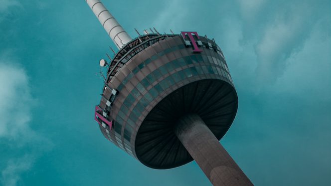 Vor türkisem Himmel ragt der Kölner Fernsehturm schräg ins Bild