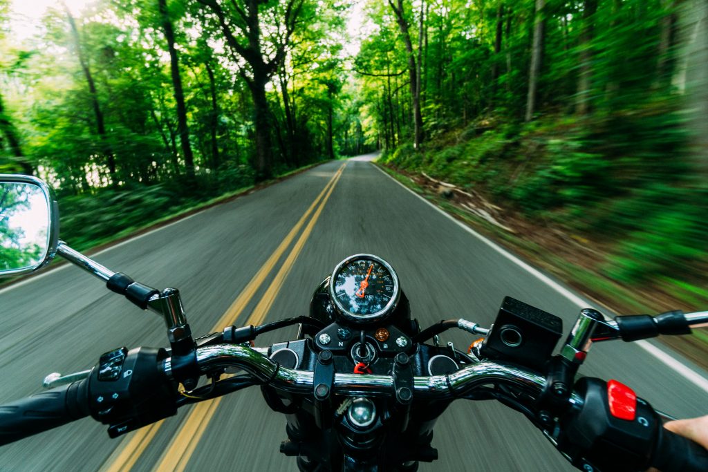 Foto vom Fahrersitz eines Motorrads bei der Fahrt aufgenommen