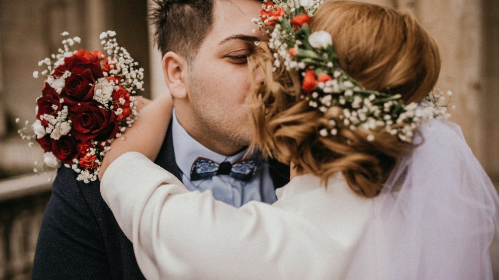 Ein innig küssendes Paar nach der Hochzeit